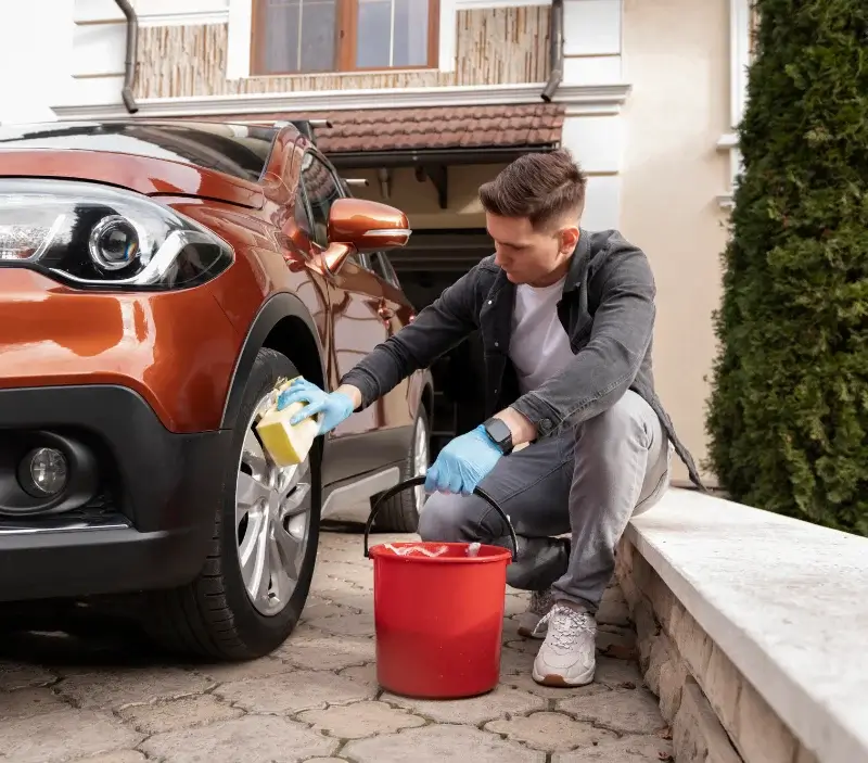 Lavage auto à domicile Le Mesnil-Saint-Denis : professionnel intervenant sur un véhicule